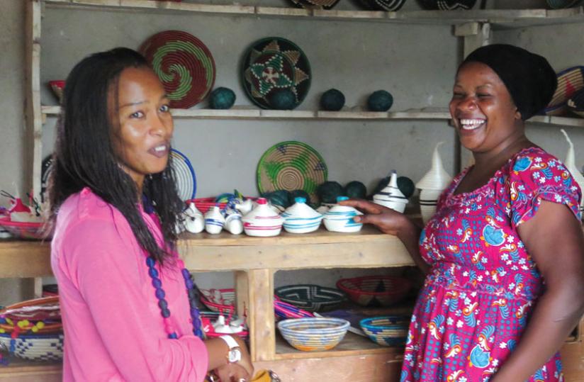 Christine Kado, a handicrafts maker in Byimana, Ruhango District (right), shares a light moment with Beauty of Rwandau00e2u20acu2122s Salha Kaitesi. Businesses like this find it hard to get outside markets for their products. Many of them are, therefore, hoping to gain a u00e2u20acu02dctricku00e2u20acu2122 or two on how to improve  product quality and access better markets. (Stephen Nuwagira)