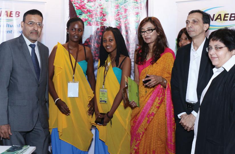Fernandesu00e2u20acu2039u00e2u20acu2039 poses for a photo with Rwandan students in India, Ingabire Linda (second left) and Nabo Max (third left) who showcased traditional Rwandan wear at the expo. Right are potential buyers of Rwandau00e2u20acu2122s coffee and tea. (Courtesy)