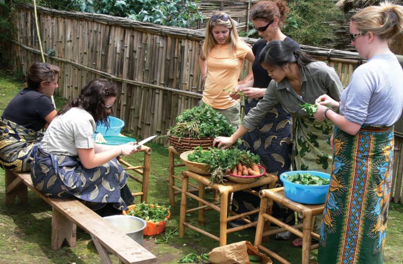 Tourists prepare vegetables in a village near Virunga National park. Communities teach tourists how to make local dishes as well as using herbs from which they earn handsomely. (Ben Gasore)