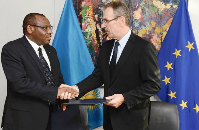 Amb. Gatete and Piebalgs exchange paperwork after the signing in Brussels. (Courtesy)