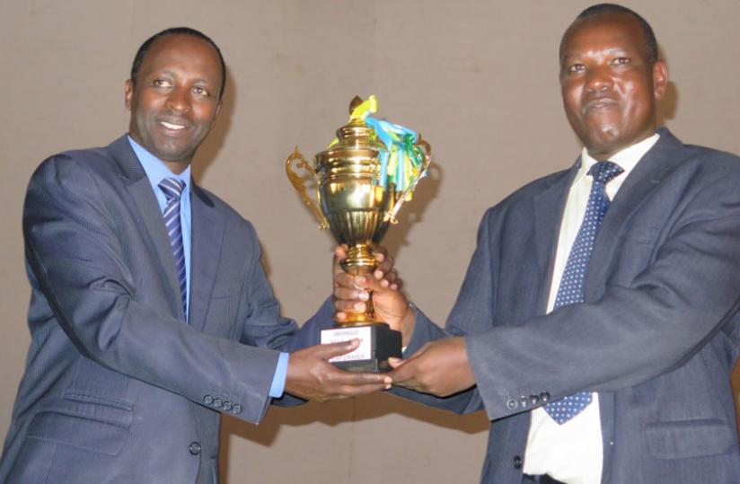Huye mayor Eugene Muzuka (R) and governor Munyantwari pose with the trophy the district was awarded in recognition of last yearu00e2u20acu2122s performance. (File)