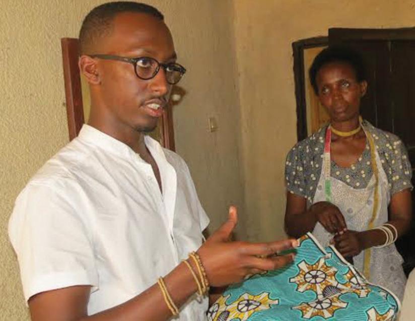 Matthew Rugamba, House of Tayo, a fashion company, proprietor, explains how to make African attire as a seamstress looks on. (File)