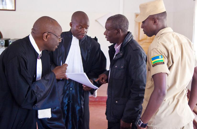 Charles Bandora ( 2nd right) consults with his lawyers; Boniface Nizeyimana (2nd left), and Mbera Ferdinand after the court session yesterday. (Timothy Kisambira)