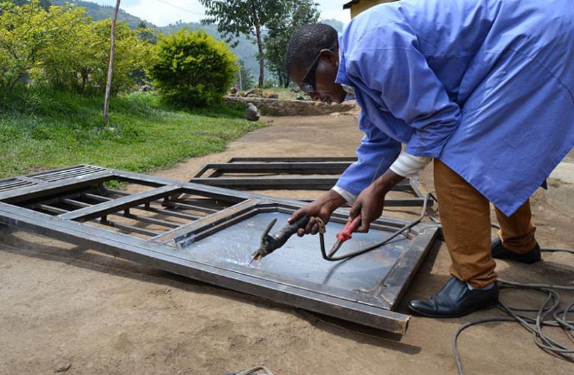 Habiyaremye welds a door at his workshop in Musanze. He says welding has greatly transformed his life. (J. du00e2u20acu2122Amour Mbonyinshuti)