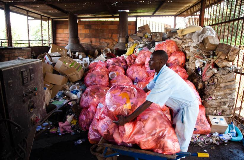 A worker at University Teaching Hospital of Kigali prepares waste to be disposed of in an incinerator. (Timothy Kisambira)
