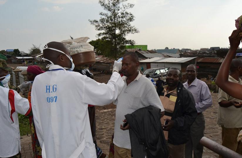 A Rwandan medical officer screens travellers for Ebola before crossing into Rwanda from DRC at  Petite Barriere in Rubavu recently. (Jean du00e2u20acu2122Amour Mbonyinshuti)