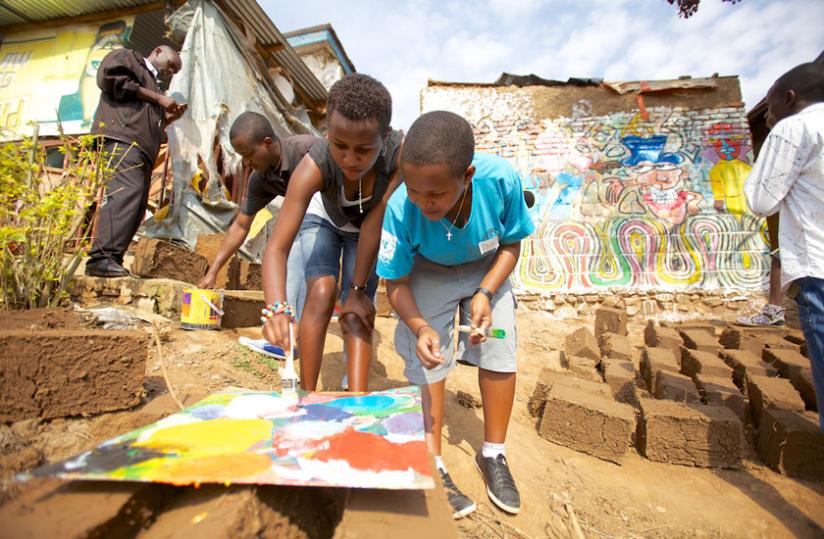 Participants work together to paint murals during Rwanda's first 'Arts Umuganda'. (Tom Gilks)