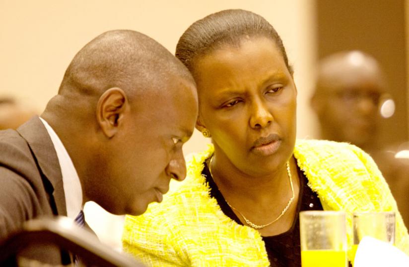 Private Sector Federation chairperson Benjamin Gasamagera (L) consults with EAC affairs minister Valentine Rugwabiza during the release of new research findings on EAC Common Market Protocol in Kigali yesterday.(Timothy Kisambira)