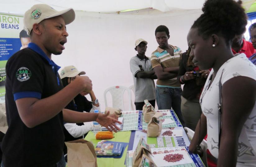 An exhibitor explains the benefits of  high iron bean varieties and vitamin A maize cobs to residents of Nyanda District on Tuesday. (Jean-Pierre Bucyensenge)