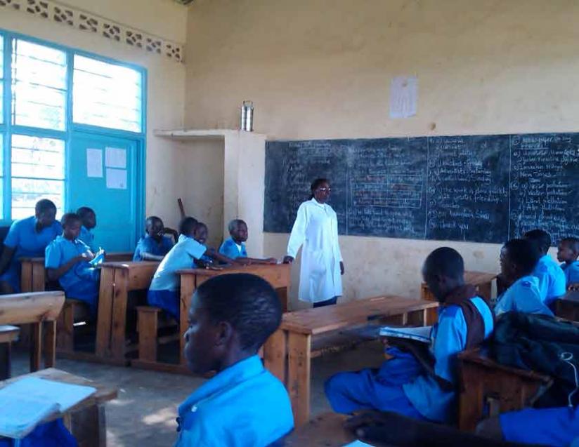 A teacher interacts with learners in class. Teachers say their welfare has improved but challenges remain. (Solomon Asaba)