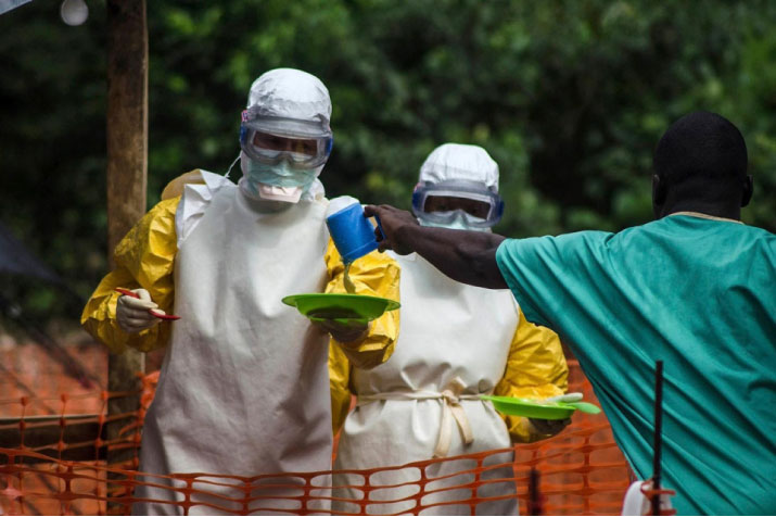 Doctors Without Borders staff take food to patients in an isolation area at the groupu00e2u20acu2122s Ebola treatment centre in Kailahun, Sierra Leone, on July 20. (Reuters)