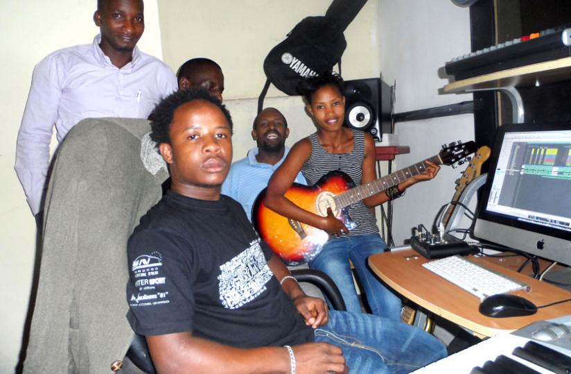 Dusabe, aka Moosa Ewan, poses with some of his artistes in the studio. (Moses Opobo)