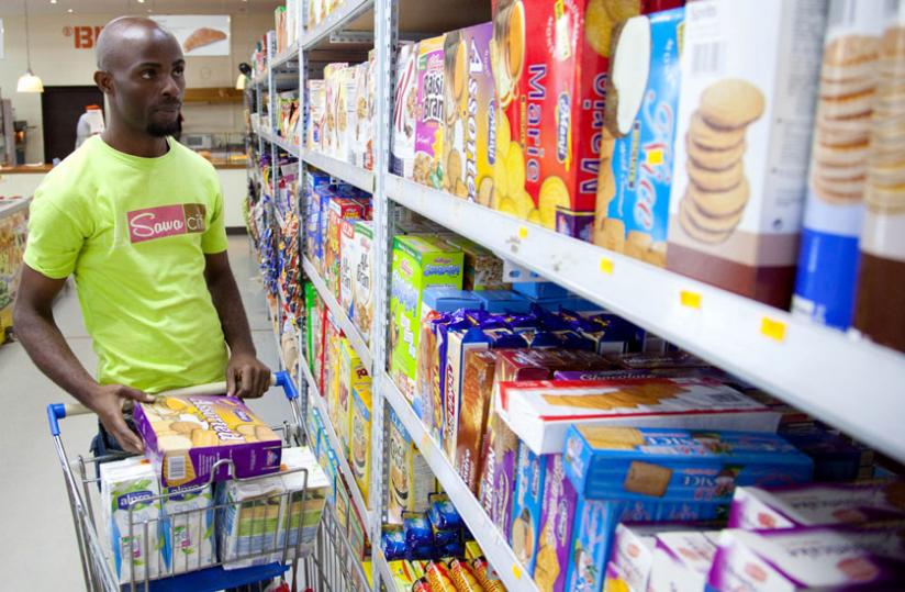 A sworker stocks biscuits at a city supermarket. WHO seeks to regulate advertising of  such foods. (Courtesy)