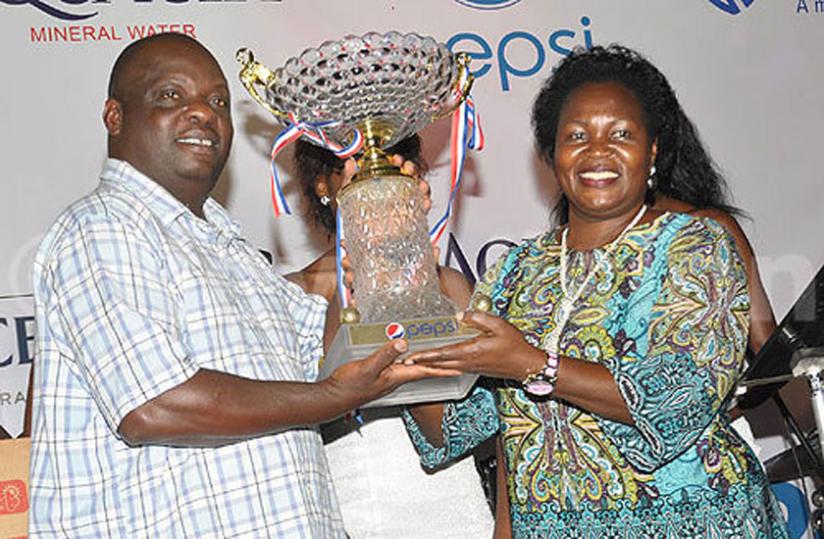 Kashaka, left, receives the overall winners trophy from Ugandau00e2u20acu2122s state minister for fisheries Ruth Nankabirwa. (Courtesy photo)