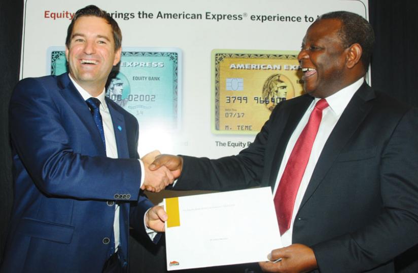 Andrew Stewart, the Partner Card Services Turkey, Middle East and Africa vice-president (left), shares a light moment with Equity Bank Group chief executive officer, James Mwangi, after signing the agreement in Kenya this week. (Net photo)