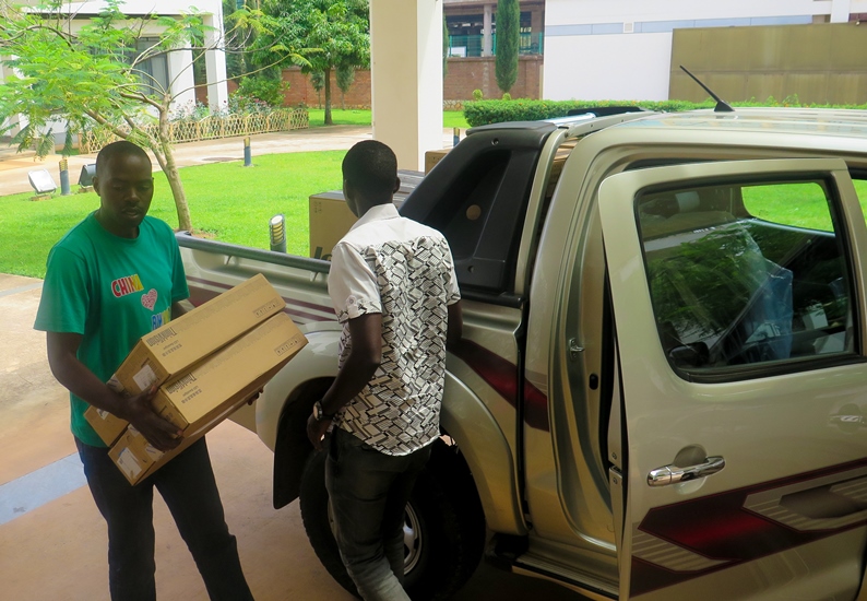 Workers  at the Chinese Embassy loading the Equipments on a car as The New Times IT Specialist Sam Sewanyana looks on. (Timothy Kisambira)