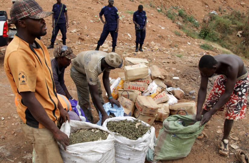 Policemen witness as illicit drugs which had been intercepted in Kicukiro are destroyed at Nduba dumping site last June. (John Mbanda)