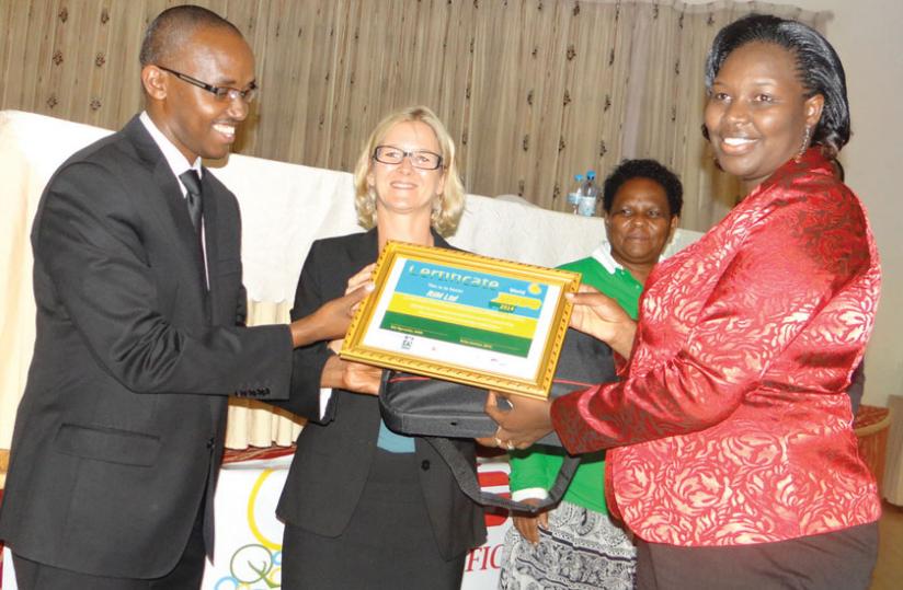 Uwimbabazi (right) receives the award from Rwigamba (left) as SBFICu00e2u20acu2122s Britta Konitzer looks on. (Peterson Tumwebaze)