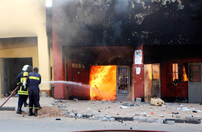 Fire fighters try to contain a blaze that razed shops on Mateus street in Kigali in July. (File)