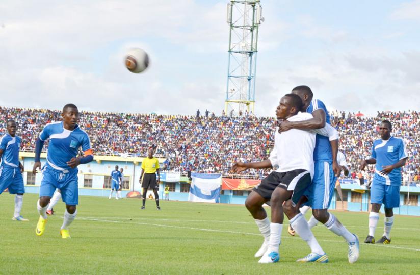 APRu00e2u20acu2122s Charles Tibingana (in white) fights for the ball with Abouba Sibomana as Rayon Sports captain Fuadi Ndayisenga (left) looks on during last yearu00e2u20acu2122s encounter at Amahoro National Stadium. (Timothy Kisambira)
