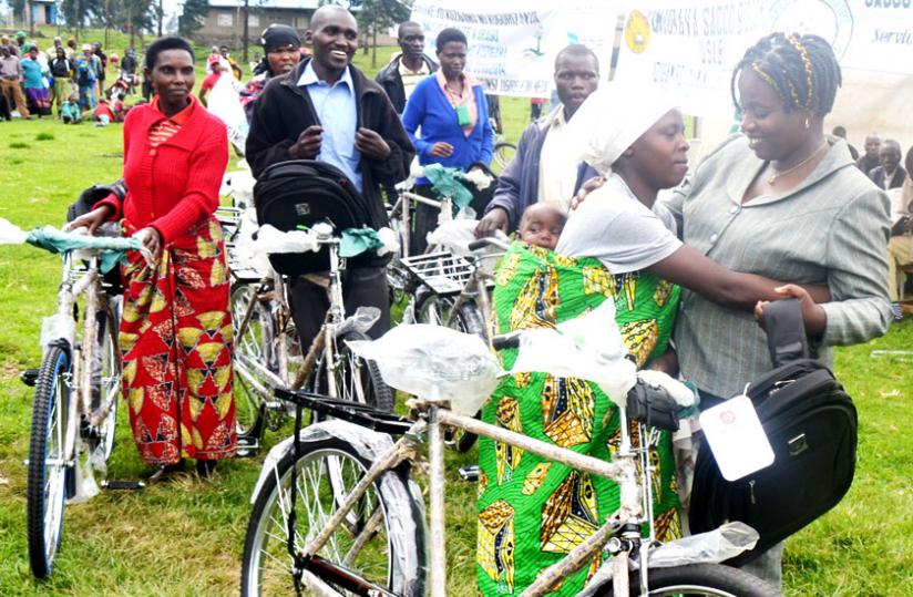 Angel Mukaminani, Nyabihu vice mayor for economic affairs (R), awards community mobilisers in savings culture with a bicycle. (Jean du00e2u20acu2122Amour Mbonyinshuti)rn