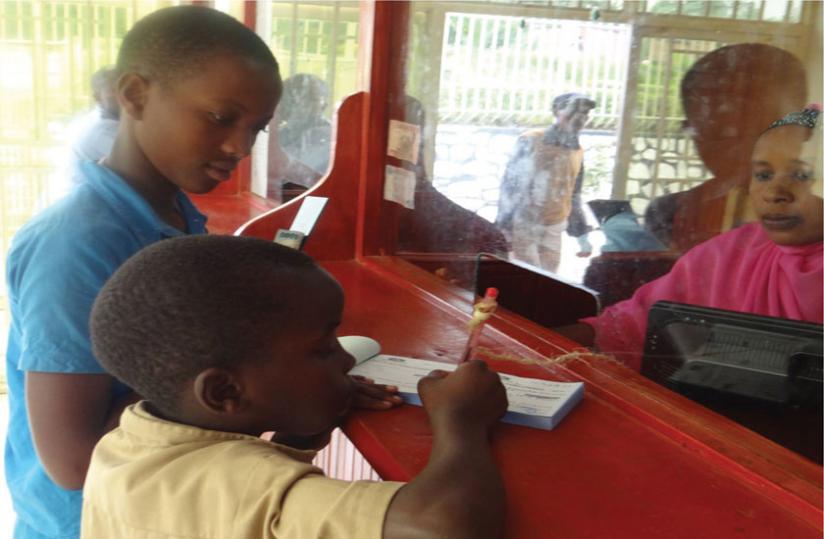 A young saver fills a form to deposit money at a city bank recently.
