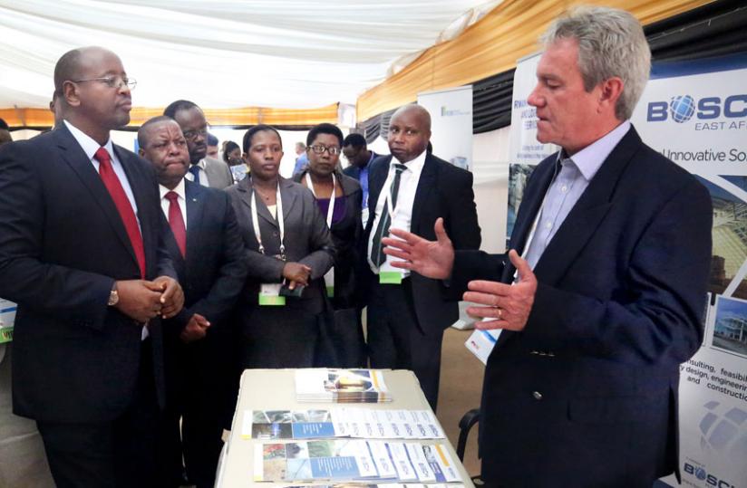 The Minister for Infrastructure, James Musoni (L), listens to Butch Carr, the energy director at Bosch projects, as other officials look on at the power and infrastructure investment forum in Kigali yesterday. (John Mbanda)