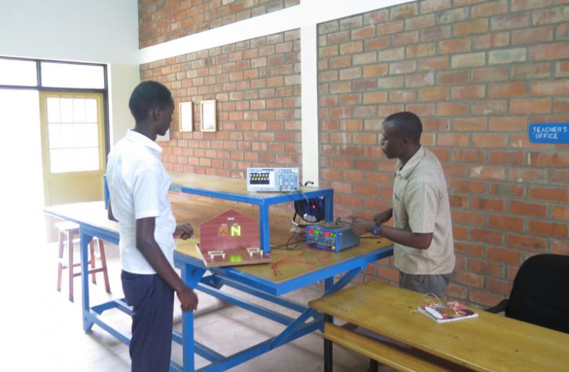 Kamuhanda explains to a student how it is done. He says there are plenty of opportunities that can earn a technician good money. (Arnold Agaba)