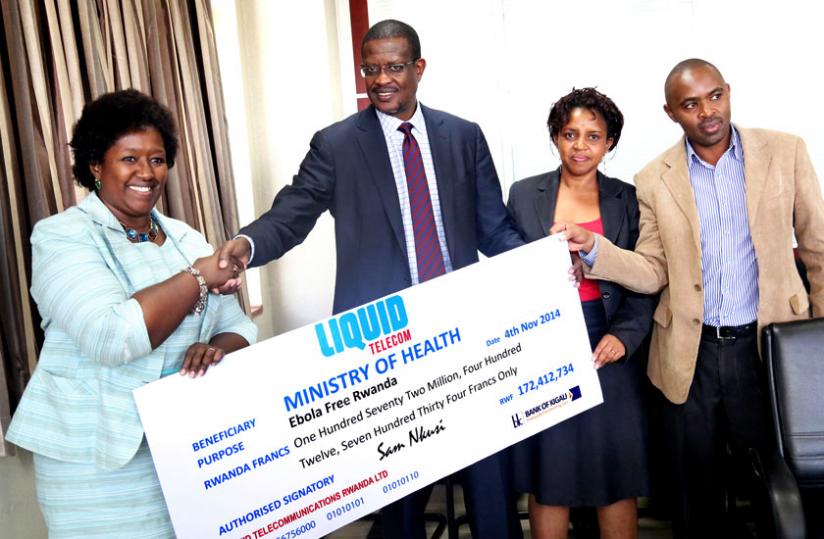 The Minister for Health, Dr Agnes Binagwaho (L), receives a dummy cheque from Sam Nkusi, Chairman, Liquid Telecom Rwanda, as Laetitia Murego, the Chief Marketing Officer and Gideon Kagayi, the Chief Finance officer look on in Kigali yesterday.rn(John Mbanda)