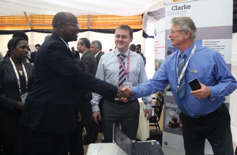 Minister for Infrastructure James Musoni (left), greets Paul de Mattos (right), the managing director of Clarke Energy, as Alex Marshall, the companyu00e2u20acu2122s marketing manager looks on during the power and infrastructure investment forum held in Kigali on Monday. (John Mbanda)