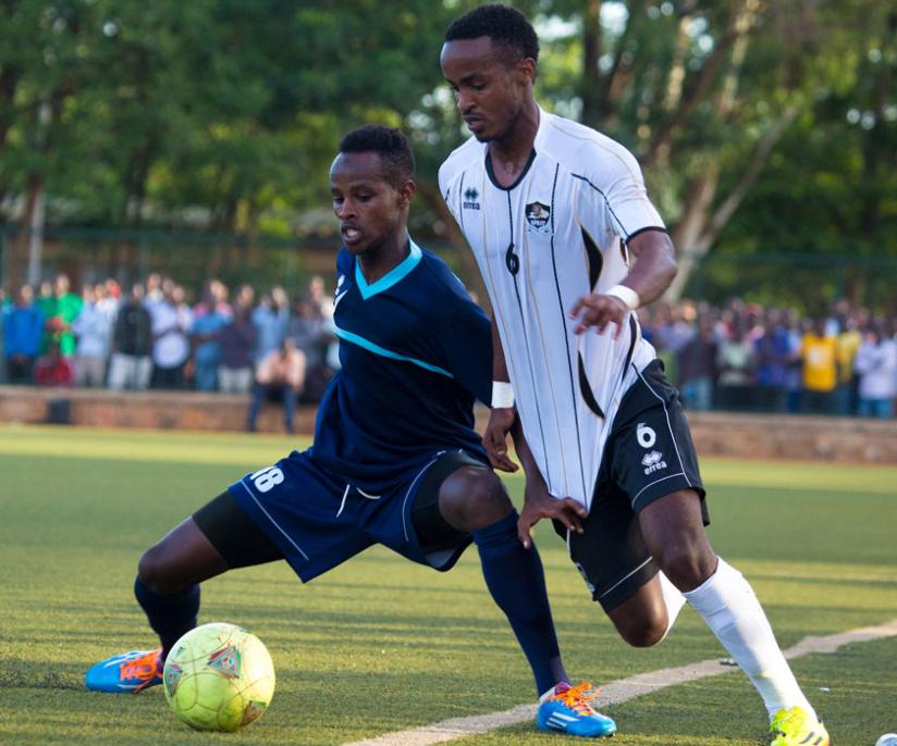 Police midfielder Rachid Kalisa ( Blue jersey)  shields the ball from Yannick Mukunzi  of APR FC yesterday at Kicukiro stadium. (T. Kisambira)