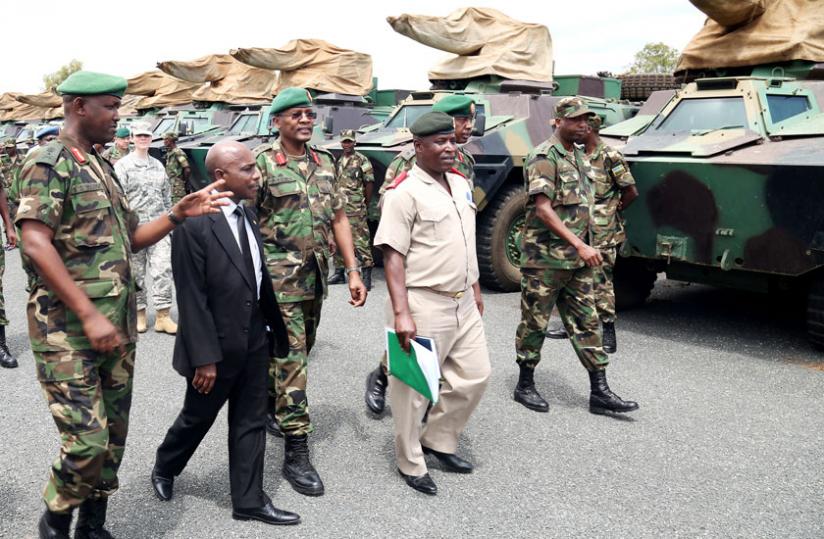 Brig. Gen. Aloys Muganga (L) shows some of the military hardware to EASF Director Ismail Chanfi (2nd L), the Force Commander Brig. Gen. Domitien Kabisa (2nd R) and other officials at Kami Barracks yesterday. (John Mbanda)