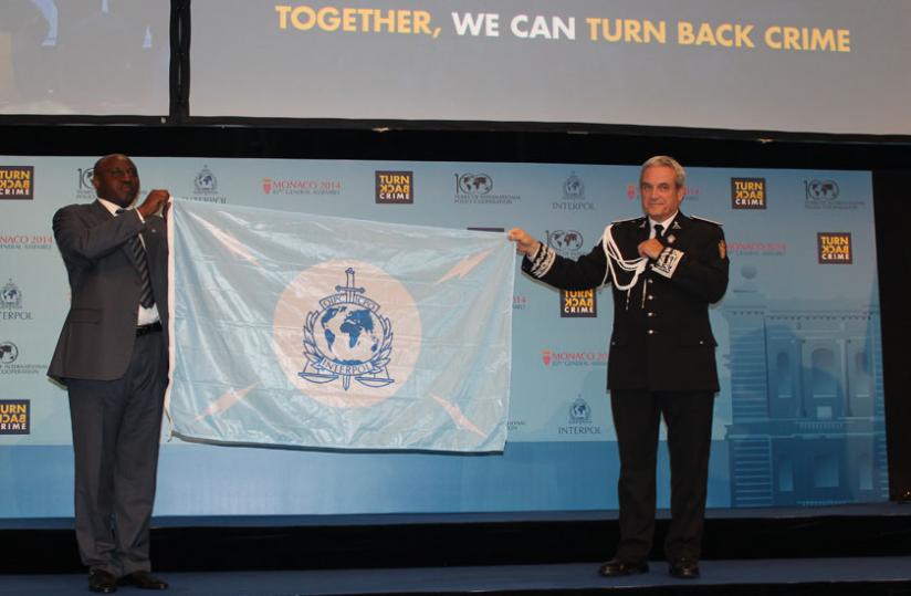 IGP Emmanuel K. Gasana receives Interpol flag from Monaco Police chief, as the host of the next AGM. (Courtesy)