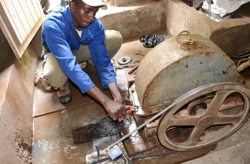 Nziyonsenga fixes the turbine he uses to generate electricity at his power house. He generates two kilowatt in Nyabihu and another one kilowatt  in Muhanga. (Jean d'Amour Mbonyinshuti)