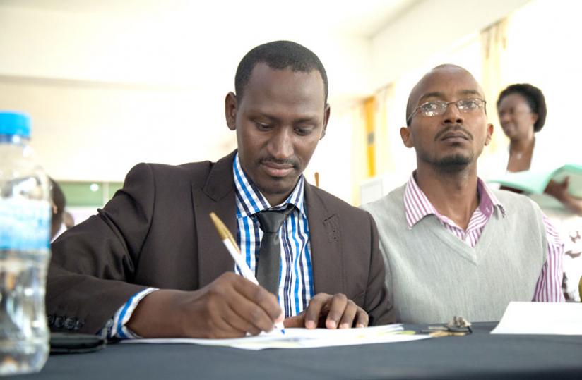 Samuel Munana, Executive Director of Rwanda National Union of the Deaf, signing the grant. (Timothy Kisambira)