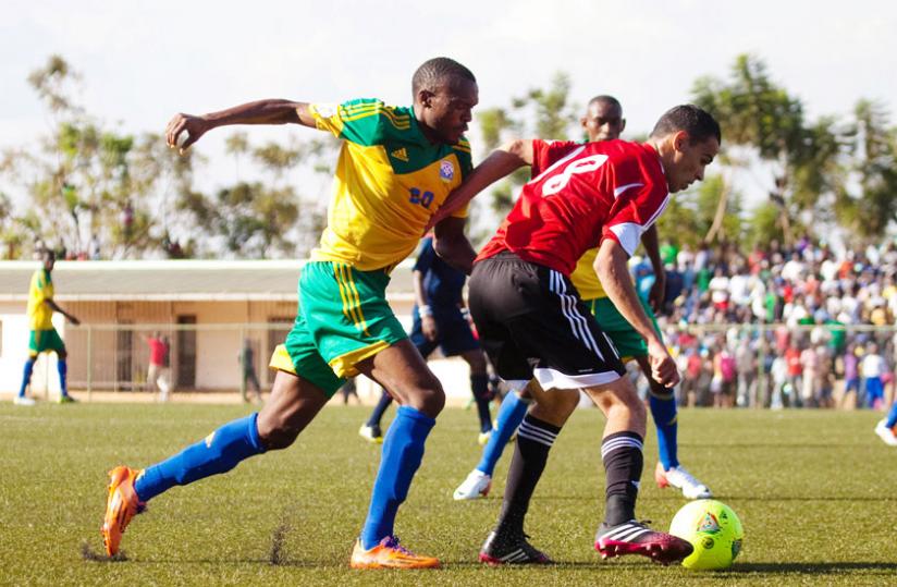 Amavubi striker Jacques Tusiyenge tries to get past a Libya defender in an Afcon qualifier in July. Amavubi players are adamant delayed wages wonu00e2u20acu2122t affect their performance tomorrow. (File)