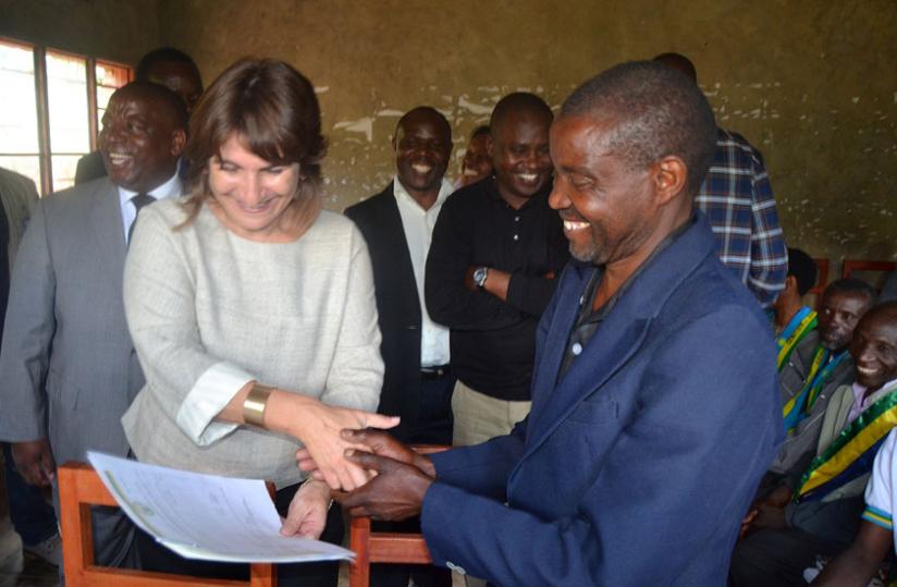 Minister Ploumen hands a land certificate to a Musanze resident on Wednesday. (Jean du00e2u20acu2122Amour Mbonyinshuti)