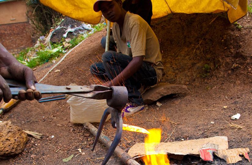 Juvu00c3u00a9nal Mugabo starts the process of making a fork hoe. (Timothy Kisambira)rn