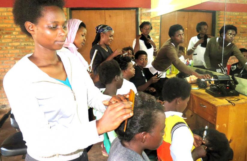 Agnes Uwimana doing hair dressing as part of her training.  (Stephen Rwembeho)