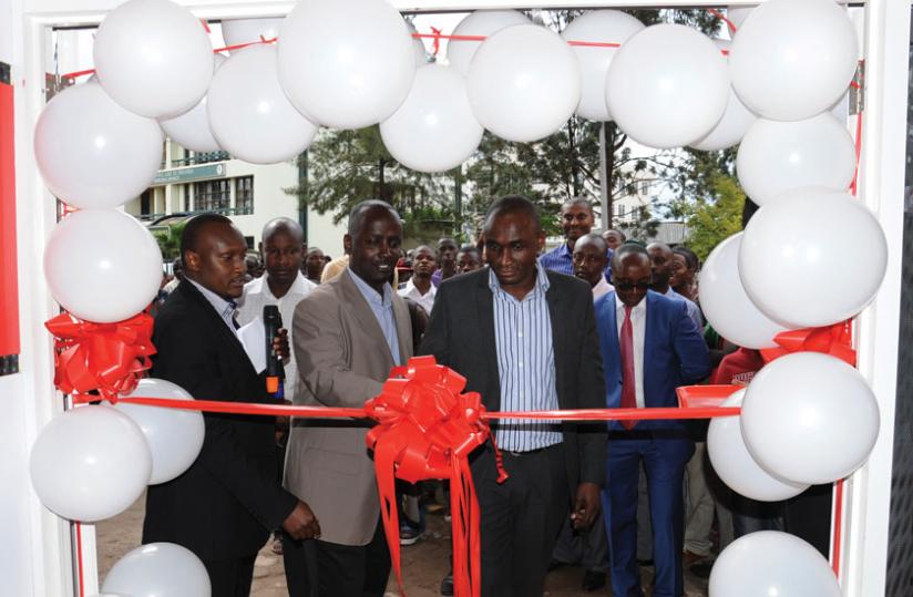 (L-R) Alex Mugisha, the Airtel Rwanda head of customer services, Kiiza and Oware cut the ribbon to officially launch the new Airtel Service Centre in Kimironko. (Ben Gasore)