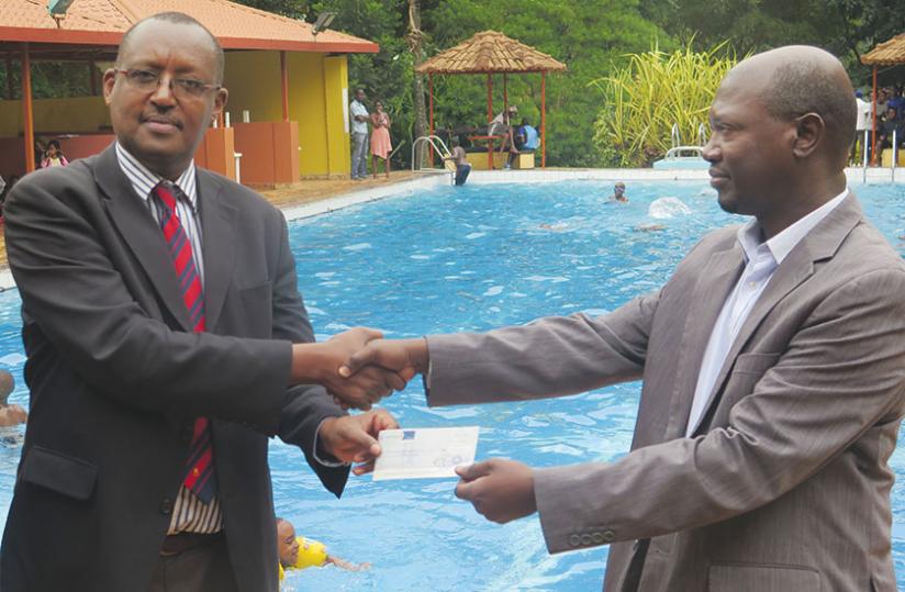 Kagabo (left) receives the contribution from CSKu00e2u20acu2122s Rwabuyonza yesterday. (Emmauel Ntirenganya)