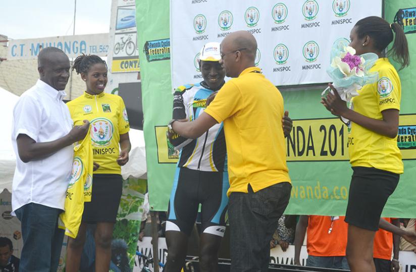 Valens Ndayisenga being congratulated by cycling federation president Aimable Bayingana as Sports Minister Joseph Habineza is about to give him the yellow jersey. (Peter Kamasa)