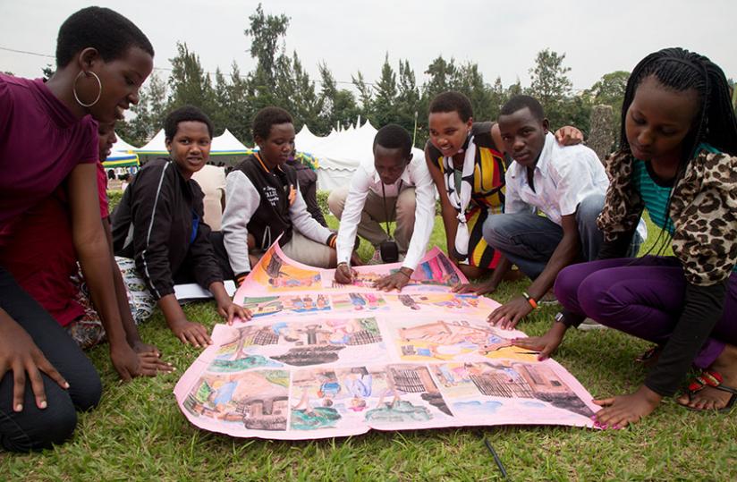 Children from Kicukiro District discuss an art piece they were due to present in a competition at Redcross offices in Kigali yesterday. (Timothy Kisambira)