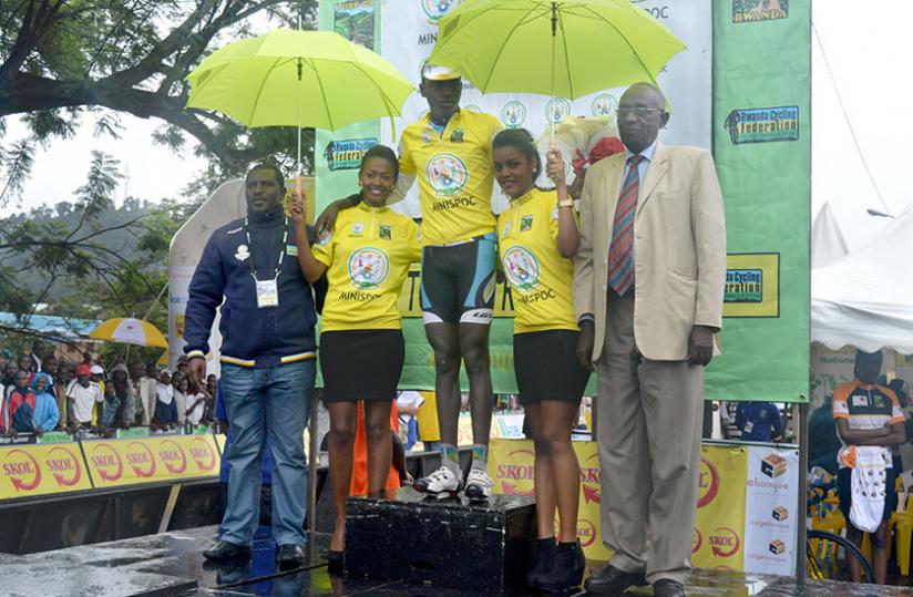 Ndayisenga relishes the moment after retaining the iconic Yellow Jersey which was bestowed upon him by Senator Chrysologue Karangwa (right) after finishing a decent fourth in the touru00e2u20acu2122s fourth stage. (Peter Kamasa)