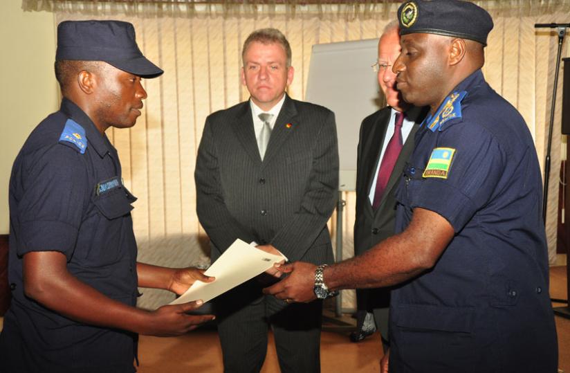 IGP Gasana gives a certificate to one of the Police trainees as German envoy Peter Fahrenholtz looks on. (Courtesy)