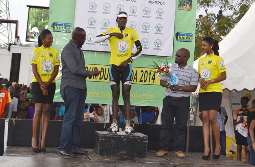 Sports Minister Joseph Habineza (L) and Minister of Youth & ICT Jean-Philbert Nsengimana looking on proudly as Ndayisenga wears the yellow jersey at Nyamirambo Regional Stadium yesterday. (Peter Kamasa)