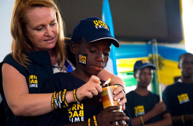 The head of Communication at Interpol   Alison  Bernard, launches the u00e2u20acu0153Stop the Crime campaign with a child at Petit Stade yesterday. (Timothy Kisambira)