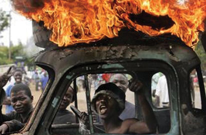A man sits in the cabin of a destroyed truck during 2007-2008 post-election violence in Kenya. (Net photo)