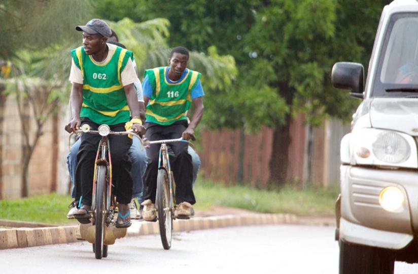 Bicycle-taxi ridders ferry passengers in Kicukiro. (Timothy Kisambira)