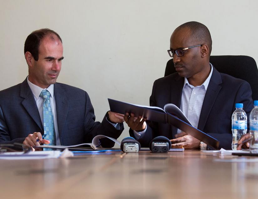Flus, the deputy head of Israeli development cooperation agency Mashav, exchanges ducuments with PS Musabyimana at the Agriculture ministry offices in Kigali yesteday. (Timothy Kisambira)